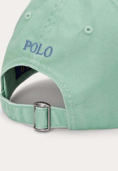 Svetlo zelena baseball kapa na zadnji strani z nastavljivo kovinsko zaponko in modrim vezenim logotipom "POLO" nad odprtino.