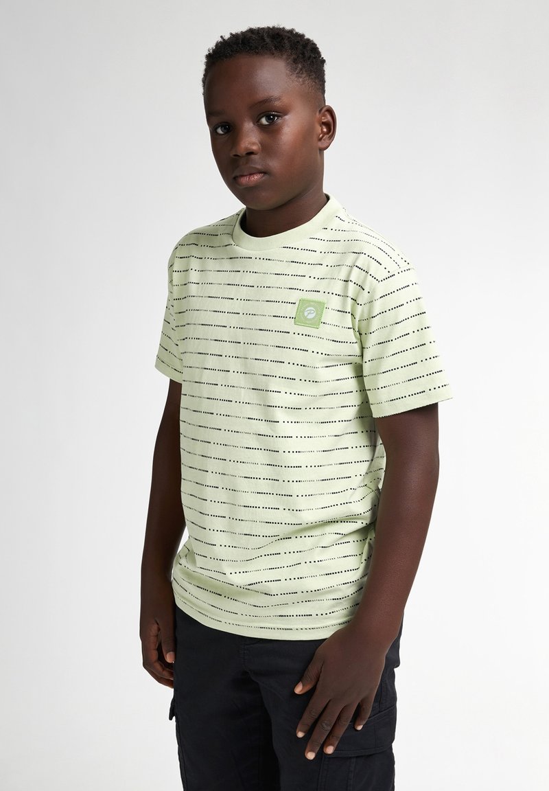 Camiseta verde claro con rayas negras horizontales, cuello redondo y un pequeño parche con un logo cuadrado en el lado izquierdo del pecho. Mangas cortas.