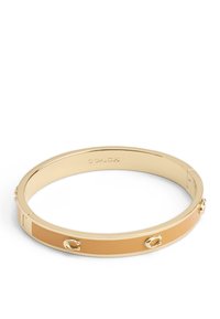 Bracciale rigido in metallo tono oro con una finitura in smalto beige liscia. Accentuato con piccoli dettagli in metallo. Design rotondo e lucido.