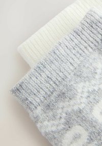 Calcetines de lana en gris con un patrón claro y puño acanalado en crema. Textura suave, forma rectangular y diseño acogedor.