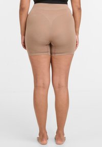 Béžové tvarující šortky s vysokým pasem. Měkká, elastická tkanina, bezešvý design a střih do poloviny stehna pro hladké tvarování.