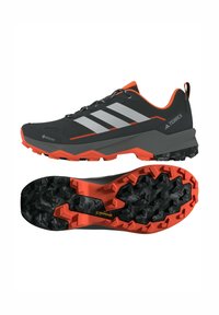 Czarne buty trekkingowe z szarymi paskami, pomarańczowymi akcentami, teksturowaną cholewką Gore-Tex oraz wytrzymałą czarno-pomarańczową podeszwą zaprojektowaną z myślą o przyczepności.