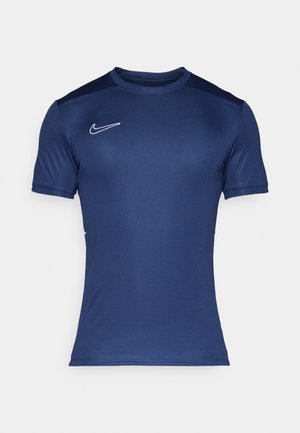Camiseta deportiva de manga corta azul marino hecha de un tejido suave. Presenta un logo de Nike blanco en la parte superior izquierda del pecho y hombros en contraste.