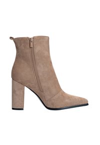 Bota de tobillo de ante beige con punta afilada, cremallera lateral y tacón grueso. Textura suave y acentos de diseño minimalista.