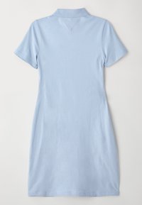 Lys blå polo kjole laget av mykt stoff, med klassisk krage, korte ermer og en litt innsnittet form for en tettsittende look.