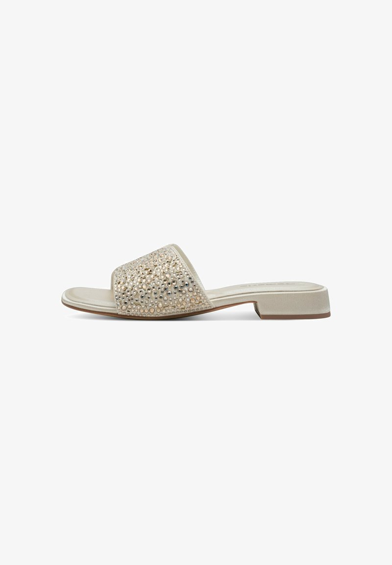 Sandal en slide beige avec un talon plat, ornée d'un design texturé de petites perles métalliques et de sequins sur la sangle supérieure.