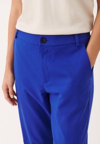 Blå bomullbyxor med rak passform, som har knäppning med knapp, bältesloopar och sidofickor. Slät textur och livfull färg.