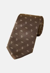 Ruskea solmio, jossa on teksturoitu pinta ja vaaleanbeige geometrinen timanttikuvio. Rullamuotoilu helpompaa säilytystä varten.