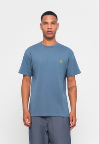 T-shirt en coton bleu à manches courtes et col rond. Présente un petit logo jaune sur la poitrine gauche. Coupe simple et décontractée.