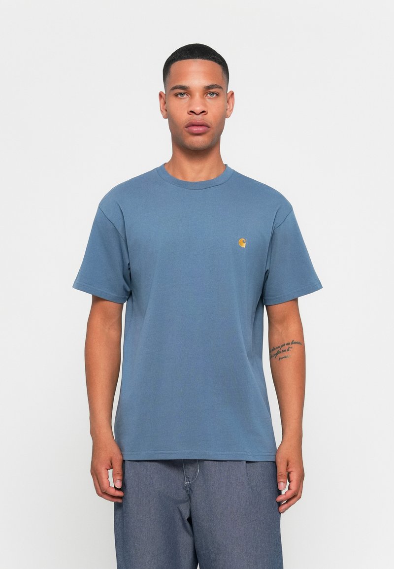 T-shirt en coton bleu à manches courtes et col rond. Présente un petit logo jaune sur la poitrine gauche. Coupe simple et décontractée.