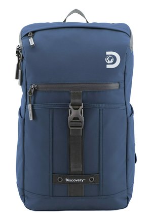 Mochila azul marino de forma rectangular, hecha de un tejido duradero. Cuenta con un bolsillo frontal con cremallera, correas ajustables y un logo en la parte frontal.