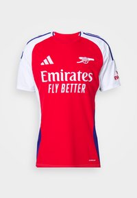 Cămașă sportivă roșie și albă cu mâneci scurte, cu guler rotund, accente albastre și logo-ul "Emirates Fly Better" pe partea din față.