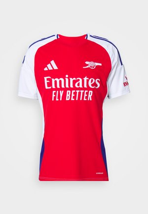 Camiseta atlética roja y blanca de manga corta, con cuello redondo, detalles en azul y el logo "Emirates Fly Better" en la parte delantera.