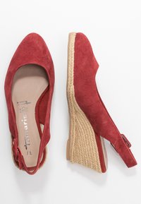Rode suède wiggschoenen met een slingback ontwerp, voorzien van een jute touw middenzool en een ronde teen. De zool is lichtbruin met een gladde afwerking.