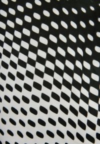 Black and white fabric with a repeating pattern of oval shapes and rectangular blocks, featuring a soft texture and contrasting color scheme.