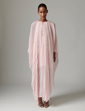 Robe longue plissée en tissu rose doux avec un col haut et un devant boutonné. Caractérisée par des manches fluides semblables à une cape et une texture légère.