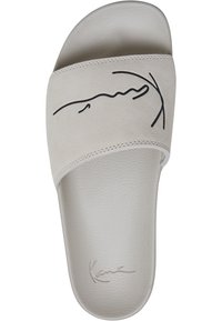 Sandal s prozračnom bež suede kožom s crnim crtežom na remenu. Ima oblikovanu unutrašnjost i teksturiranu podlogu.