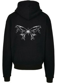 Sweat à capuche noir avec un motif abstrait de papillon blanc dans le dos, présentant des motifs d'ailes complexes semblables à des éclaboussures.