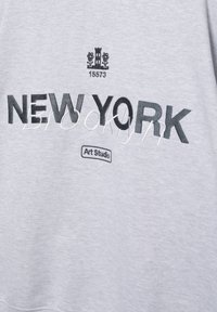 Siva tkanina z napisom "NEW YORK" v krepki črni pisavi, obris metulja, stolp z rožami in številka 15573 ter našitek "Art Studio".