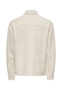 Chemise beige à manches longues en tissu texturé, poignets boutonnés et col standard, vue de dos.