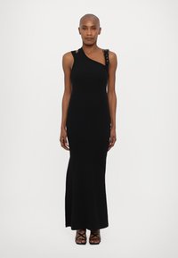 Black, asymmetrical, sleeveless dress with a textured shoulder accent featuring decorative hardware. Smooth, form-fitting fabric, floor-length design.