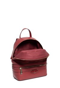 Czerwony skórzany plecak z dużym zamkiem błyskawicznym, przestronnym wnętrzem i przednią kieszenią. Posiada złote akcenty wykończeniowe oraz wytłoczony detal z logo.