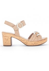 Beżowe zamszowe sandały na obcasie z korkową platformą. Posiadają okrągłą metalową klamrę oraz wplecione detale na przedniej części sandałów.