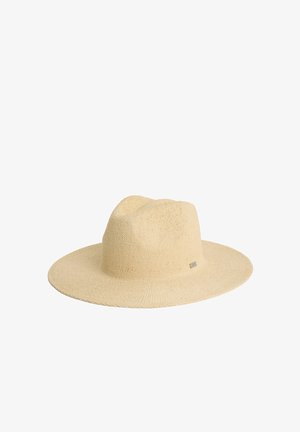 Chapeau de paille à larges bords en beige naturel, présentant un tissage texturé et un petit logo métallique sur le côté.
