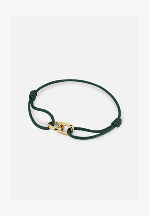 Temno zelena nastavljiva zapestnica iz vrvice z dvojnim zapahom v zlatem, poliranim odtenku na belem ozadju.