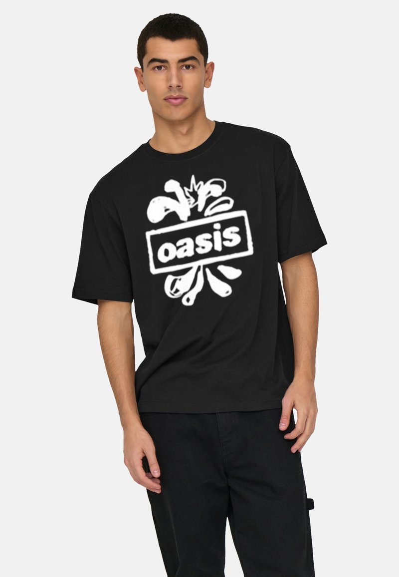 Black cotton t-shirt featuring a large white "oasis" logo with stylized graphic elements. Short sleeves and a loose fit.