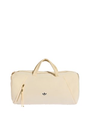 Beige blød stof duffel taske med dobbelte håndtag, front diagonal lynlåslomme og lille sort Adidas-logo midt foran.