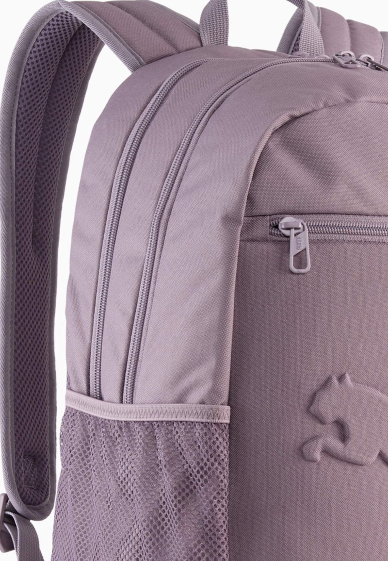 Sac à dos violet avec un tissu texturé, plusieurs compartiments zippés, poche latérale en mesh et détails de logo sur le bas à l'avant.