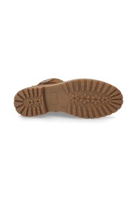 Brown rubber boot sole with deep, multi-directional treads for grip, featuring a rounded toe and rectangular detail in center.