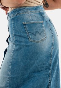 Denimrok in lichtblauw, met een hoge taille en een achterzak met een opvallend geborduurd ontwerp. Glad textuur en klassieke pasvorm.