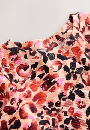 Gornji dio s leopard uzorkom u bež boji, s nijansama crvene, crne i ružičaste. Teksturirani rebrasti materijal s okruglim izrezom i kratkim rukavima.