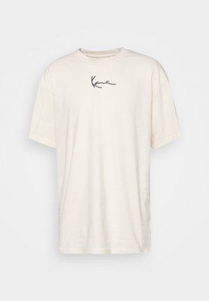 Off-white kortærmet t-shirt med en lille sort kursiv logo centreret nær halsudskæringen foran.