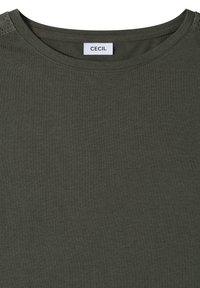 T-shirt vert foncé à col rond avec une étiquette blanche portant la mention "CECIL" cousue à l'intérieur du col.