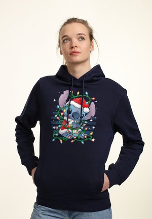 Felpa con cappuccio blu navy che presenta una grafica colorata di un personaggio con un cappello di Babbo Natale avvolto nelle luci natalizie, con una tasca a marsupio frontale.
