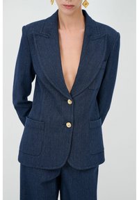 Blazer in denim blu navy con scollatura a V profonda, rever a punta, bottoni dorati e due tasche frontali. Texture liscia e design aderente.