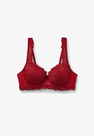 Červená krajková podprsenka s vzorovanou síťovinou na pohárcích, polstrovanou strukturou a dekorativní krajkovou podšívkou po stranách ramínek a podbandu. Uprostřed se nachází mašlička.