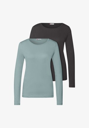 Twee lange mouwen shirts: één in licht teal en één in zwart. Beide hebben een ronde hals en een zachte textuur. Labels zichtbaar op de halslijn.
