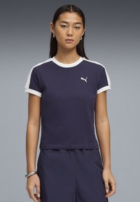 T-shirt Puma bleu marine avec accents blancs, manches courtes, col rond, coupe ajustée, et petit logo sur la poitrine. Tissu en coton lisse.