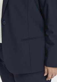 Námořnická sako s jednobodovým zapínáním, tailored fit, hladkou texturou a nenápadným detailem boční kapsy.