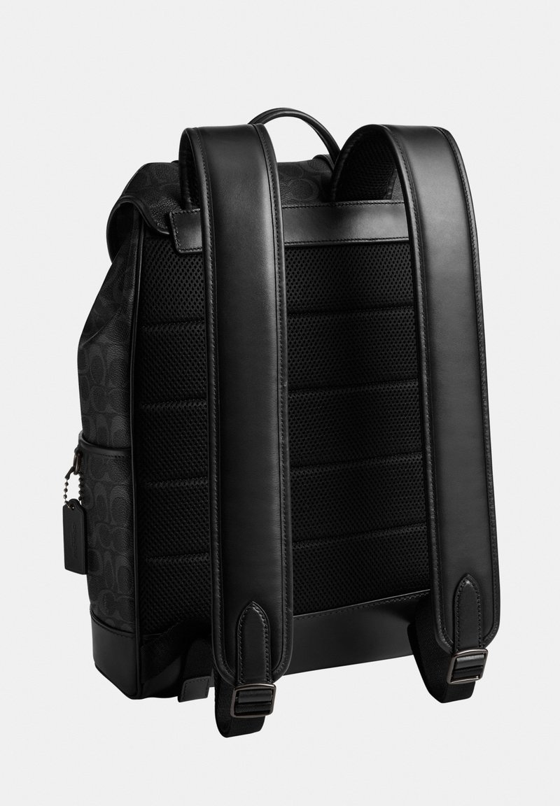 Mochila negra con panel trasero acolchado de malla, correas de hombro anchas ajustables de cuero, asa superior y bolsillo lateral con etiqueta adjunta.