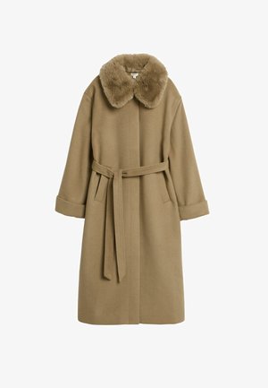 Beige ullrock med fuskpälskrage, midjebälte och vida ärmar. Har en ren design utan synliga knäppningar eller mönster.