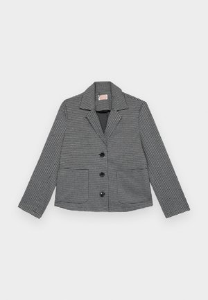 Μαύρη και άσπρη κομμένη ζακέτα με σχέδιο καρό houndstooth, με ανιχνευτή γιακά, τρία μπροστινά κουμπιά και δύο τσέπες μ patch.