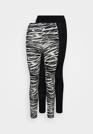 Dvoje legín: jedny s čiernobielym pruhovaným vzorom zebry a druhé v jednofarebnej čiernej. Mäkká, elastická tkanina, priliehavý strih.