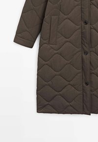 Cappotto imbottito marrone scuro con cuciture a motivo ondulato, tasca laterale, chiusura con bottoni e maniche lunghe.