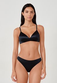 Black bikini set featuring a smooth satin texture. The bra has a plunging neckline and thin adjustable straps, paired with low-rise bottoms.