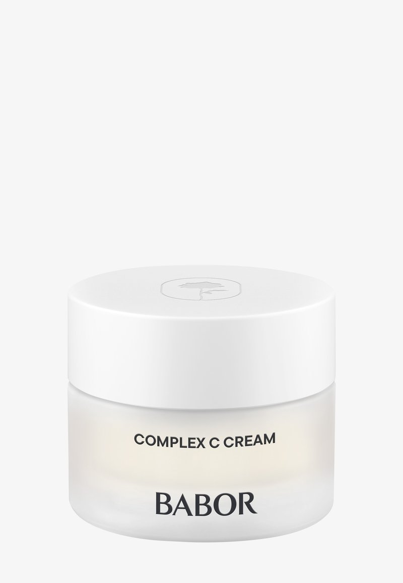 Crème C Complex de Babor dans un pot blanc lisse avec un couvercle blanc. Présente une base en verre clair avec du texte noir sur le devant.